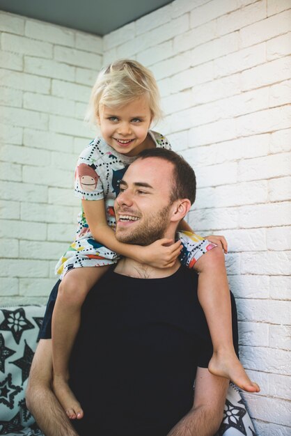 Sourire père avec sa fille sur les épaules