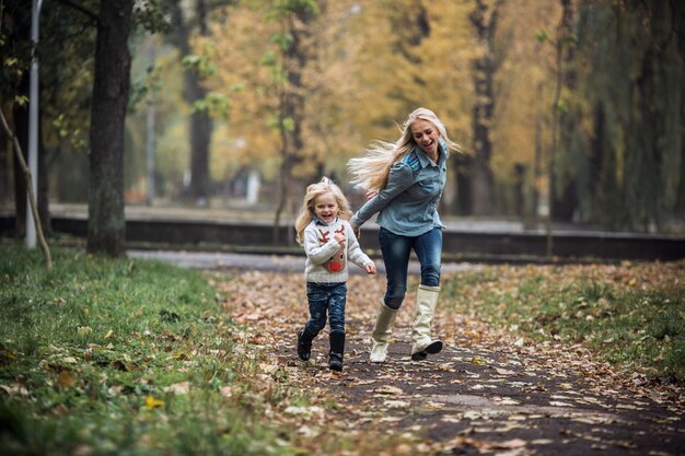Sourire petite fille jouant avec sa mère dans le parc