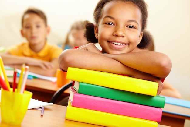 Sourire petite fille avec des livres prêts