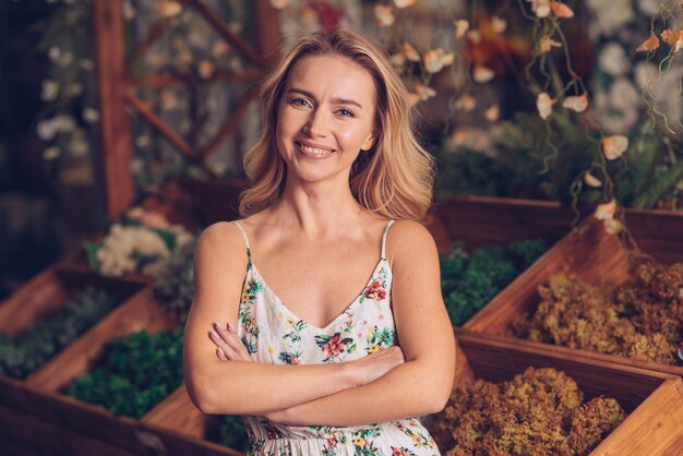 Sourire portrait de confiant jeune femme avec les bras croisés en regardant la caméra