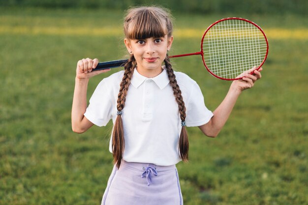 Sourire portrait d&#39;une jeune fille tenant le badminton