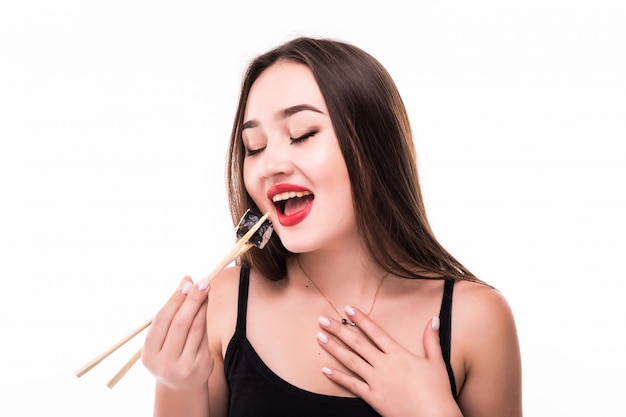 Sourire surpris femme asiatique goût sushi rouleaux habillés de lèvres rouges noirs isolés
