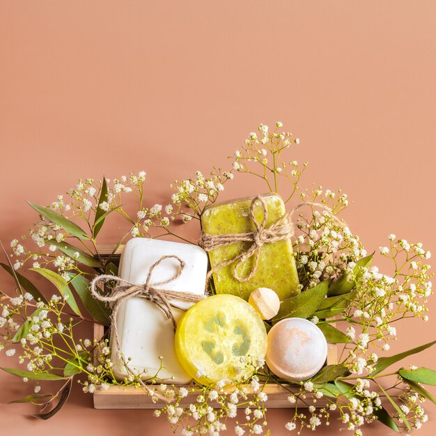 Spa et accessoires de soins du corps dans une boîte en bois sur fond coloré.