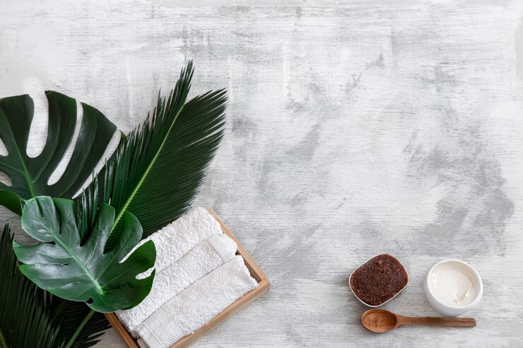 Photo gratuit spa. articles de soins du corps sur blanc avec des feuilles tropicales.