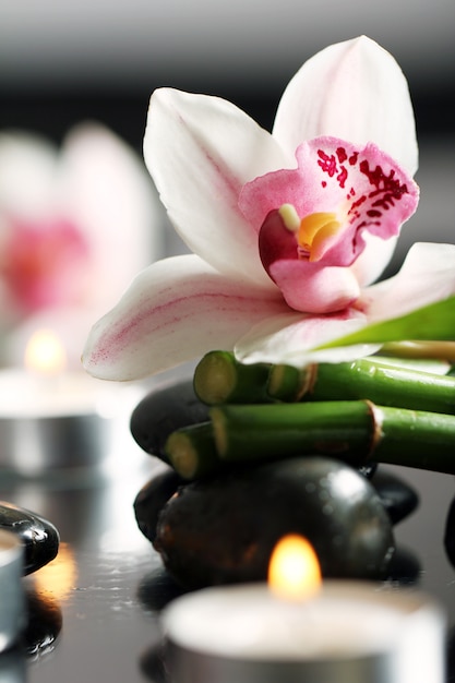 Spa et bien-être, pierres de massage et fleurs sur nappe en bois