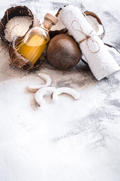 Spa nature morte de cosmétiques bio avec des noix de coco sur un fond en bois clair, concept de soins du corps