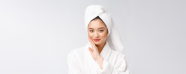 Spa skincare beauté femme asiatique sécher les cheveux avec une serviette sur la tête après le traitement de douche Belle jeune fille multiraciale touchant la peau douce