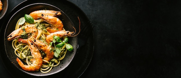 Photo gratuite spaghetti au pesto et crevettes servis dans une assiette