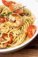 Photo gratuite spaghetti aux crevettes frites et tomates fraîches.