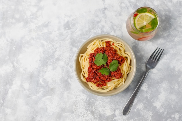 Photo gratuite spaghetti bolognaise et limonade sur béton gris