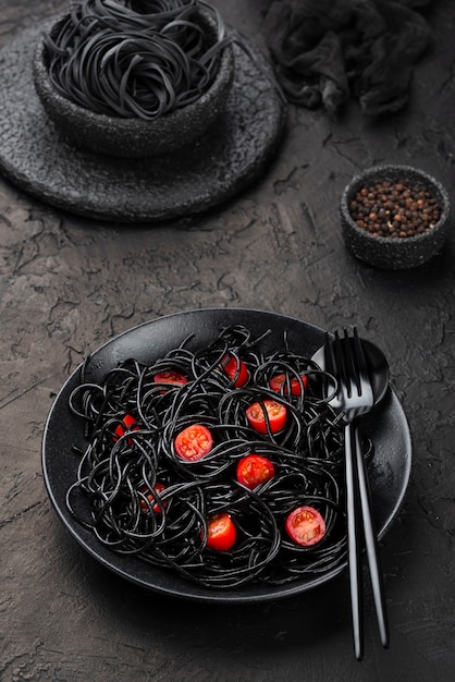 Spaghetti noir sur plaque avec tomates