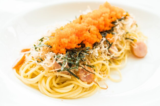 Spaghetti à la saucisse, oeuf de crevette, algues, calmars secs sur le dessus