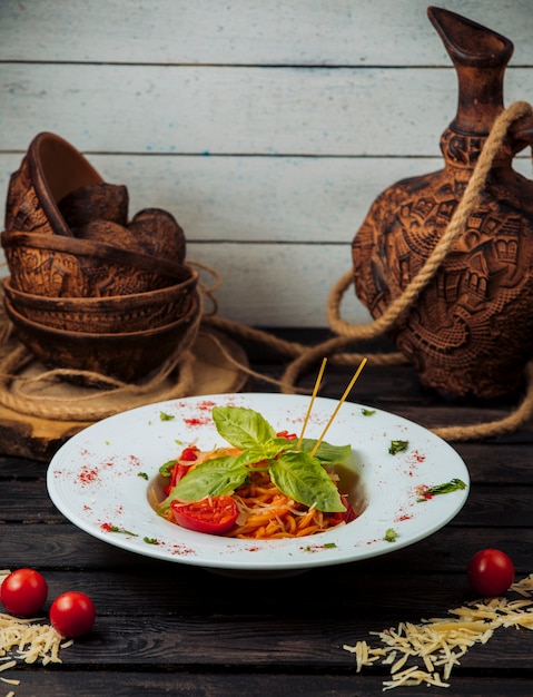 Photo gratuite spaghetti à la tomate classique garnie de parmesan râpé et de basilic frais