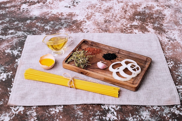 Spaghettis crus aux herbes fraîches sur nappe.