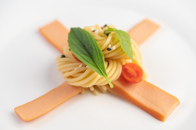 Spaghettis sautés joliment disposés dans une assiette blanche.