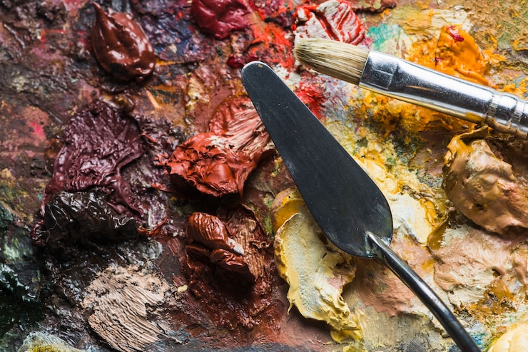 Photo gratuit spatule et pinceau sur des taches de peinture