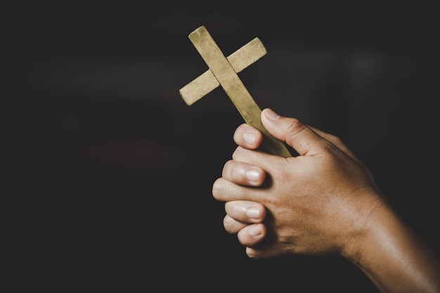 Photo gratuite spiritualité et religion, les femmes dans les concepts religieux mains priant dieu tout en tenant le symbole de la croix. nun a attrapé la croix dans sa main.