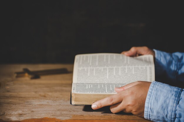 Spiritualité et religion, mains jointes en prière sur une Sainte Bible dans le concept de l'église pour la foi.