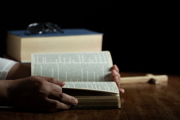 Photo gratuite spiritualité et religion, mains jointes en prière sur une sainte bible à l'église