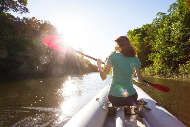 Sport d'été et actif. une fille faisant du kayak au coucher du soleil