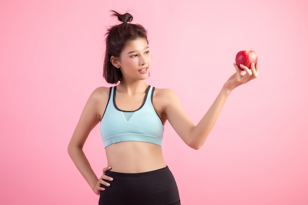 Sport femme en bonne santé tenant une pomme rouge