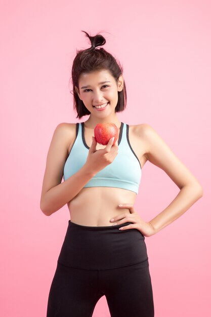 Sport femme en bonne santé tenant une pomme rouge