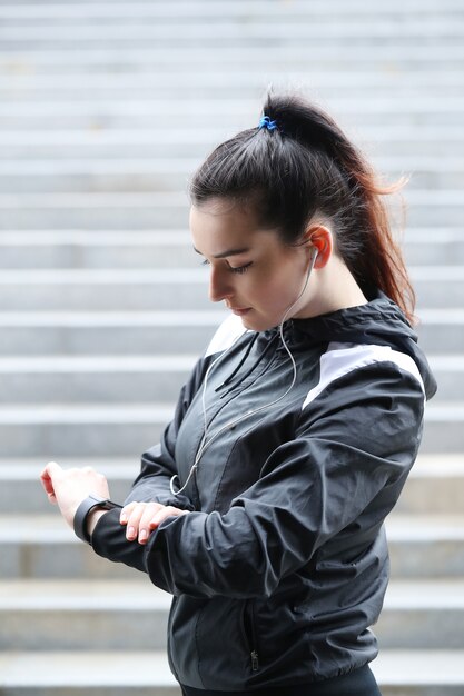 Sport femme en plein air à la recherche de sa montre-bracelet