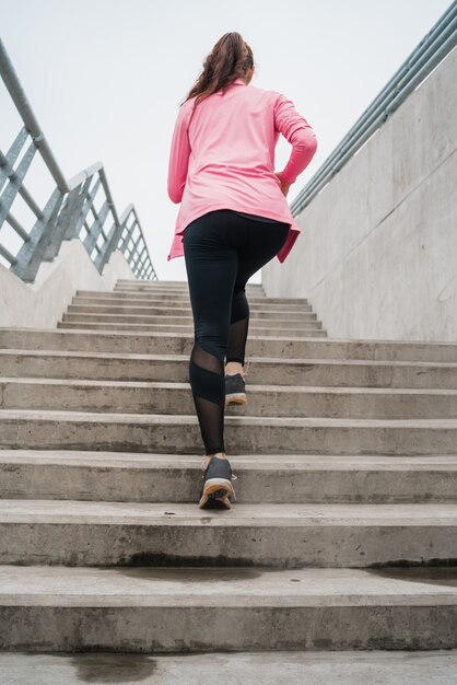 Sport femme qui court dans les escaliers.