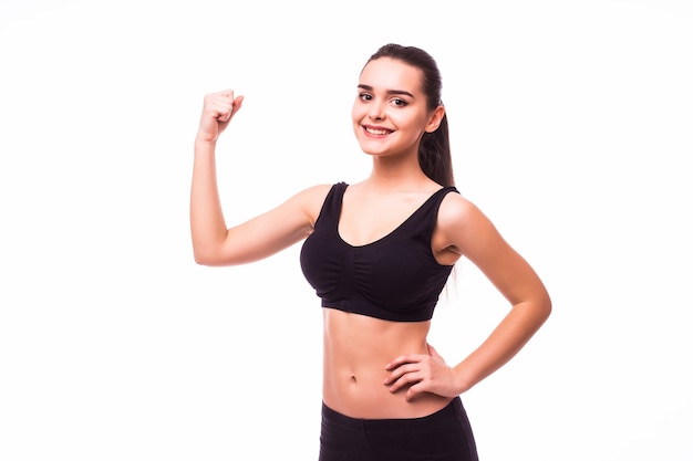 Sport jeune femme avec un corps parfait montrant les biceps, studio de fille de remise en forme tourné sur fond blanc