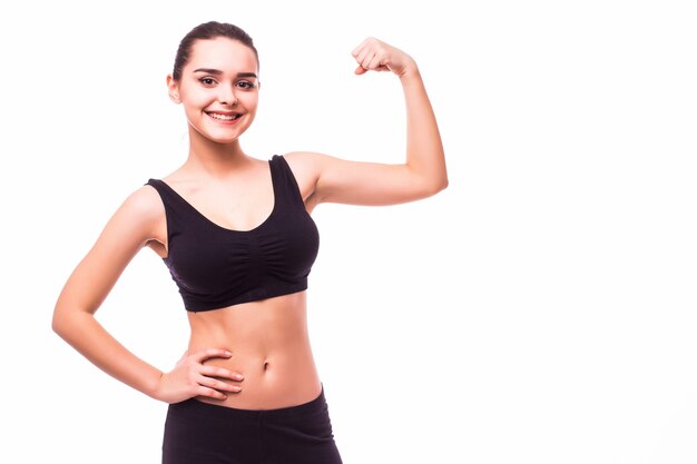 Sport jeune femme avec un corps parfait montrant les biceps, studio de fille de remise en forme tourné sur fond blanc
