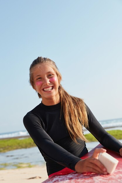 Sport de plein air, concept d'activités nautiques. Fit belle fille aime les vacances d'été, utilise une protection faciale en zinc