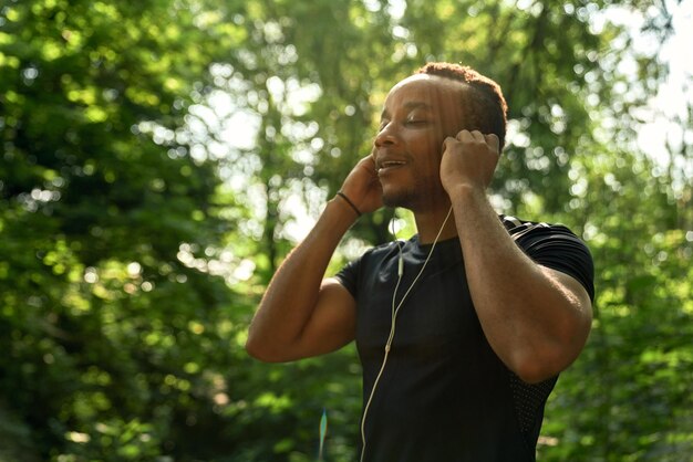 Sportif africain en t-shirt noir écoutant de la musique