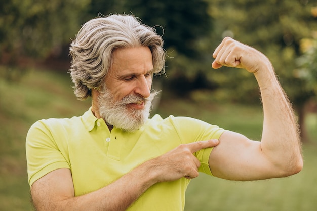 Sportif d'âge moyen pointant sur ses biceps