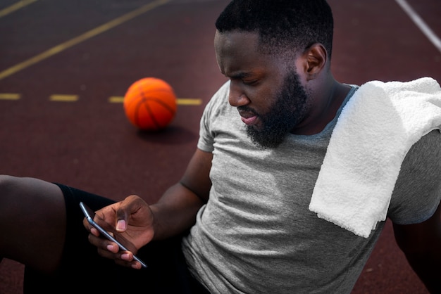 Sportif américain regardant le téléphone