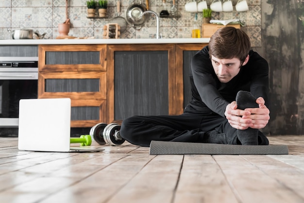 Photo gratuite sportif qui s'étend sur un tapis d'exercice