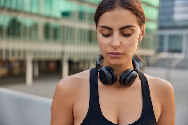 Une sportive calme et concentrée vêtue de vêtements de sport termine les poses d'entraînement contre le flou