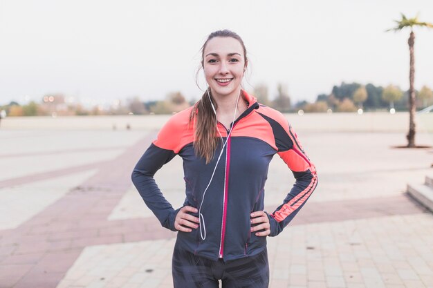 Sportswoman posant avec les mains sur la taille