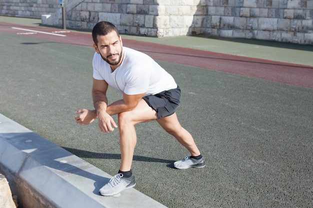 Sporty Man Stretching Calf et Penché sur le genou