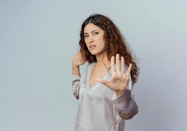 Squeamish jeune jolie femme employé de bureau montrant le geste d'arrêt isolé sur un mur blanc