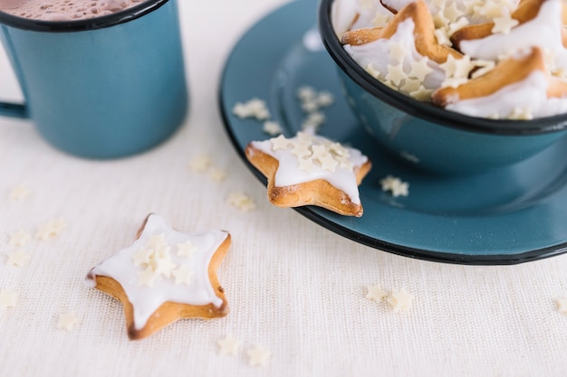 Star cookies dans un bol avec une tasse de cacao