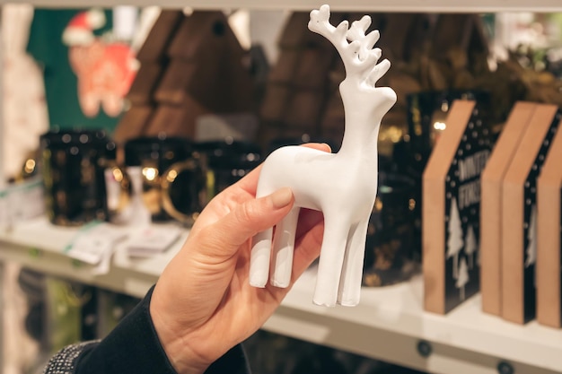 Statue décorative d'un cerf entre des mains féminines dans un magasin