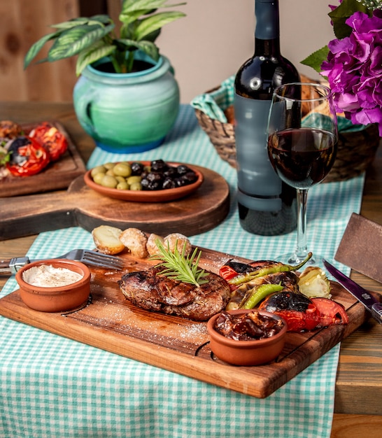 Steak bien cuit avec pommes de terre au four et légumes