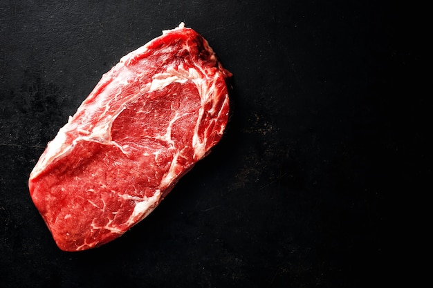 Steak de boeuf cru sur une surface sombre