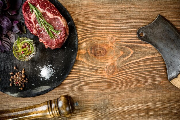 Steak de bœuf cru vieilli à sec avec des ingrédients pour griller