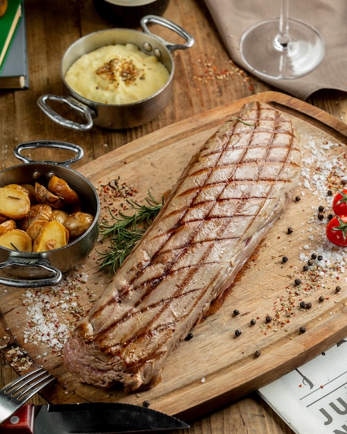 Photo gratuite steak de boeuf entier servi avec des pommes de terre, garni de sel casher