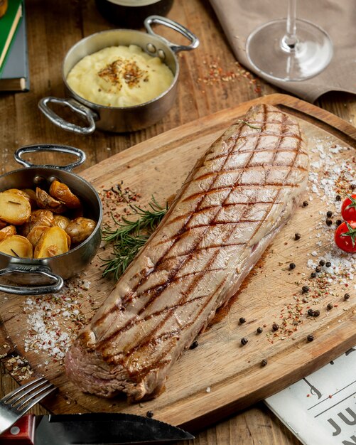 steak de boeuf entier servi avec des pommes de terre, garni de sel casher