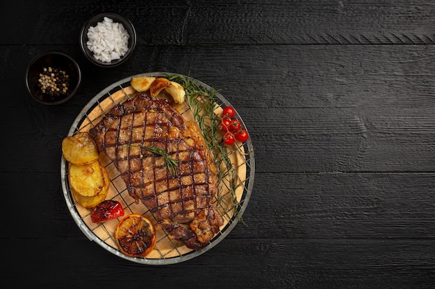 Steak de boeuf grillé sur la surface en bois sombre.