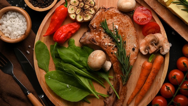 Steak de côtelette de porc grillé juteux ou steak de tomahawk servi avec des légumes grillés sains vue de dessus