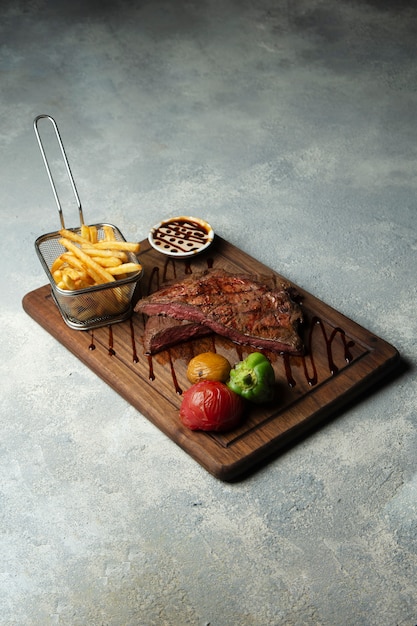 Steak cru moyen avec frites et légumes