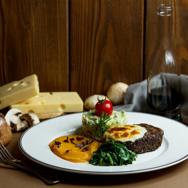 Steak grillé au fromage fondu et aux légumes en purée